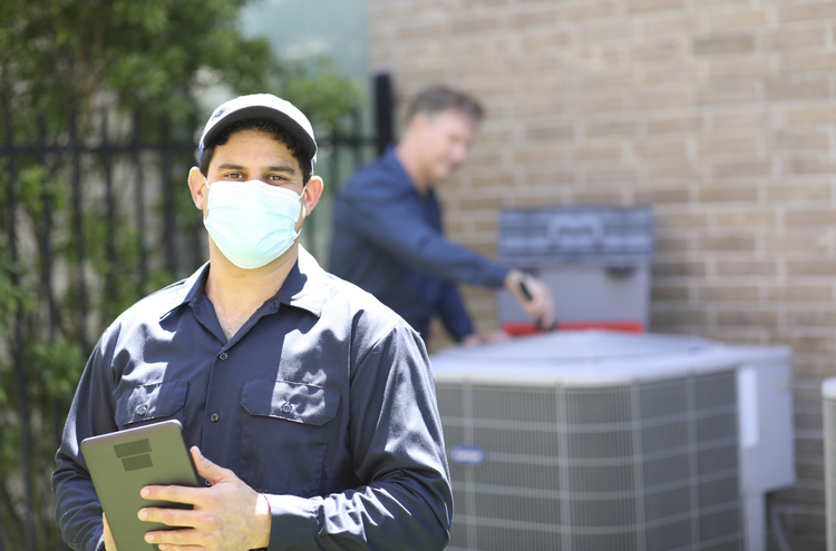 An new HVAC business owner and HVAC technician at a customers home for an air conditioner install