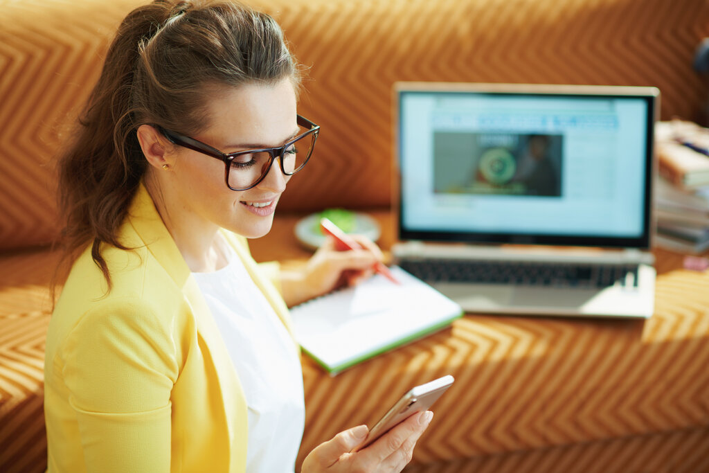 smiling woman with laptop and smartphone study online in litmos