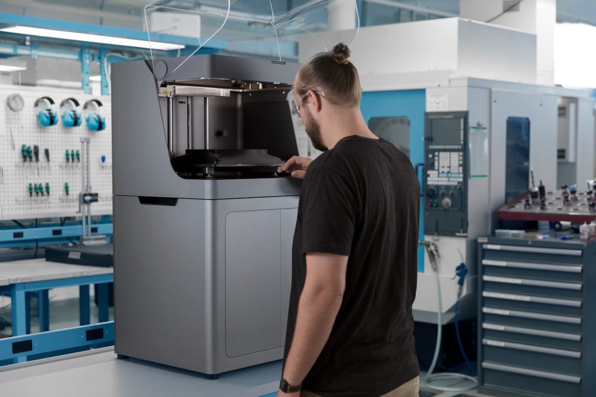 An image of a man using a Markforged industrial composite 3D printer - TPM