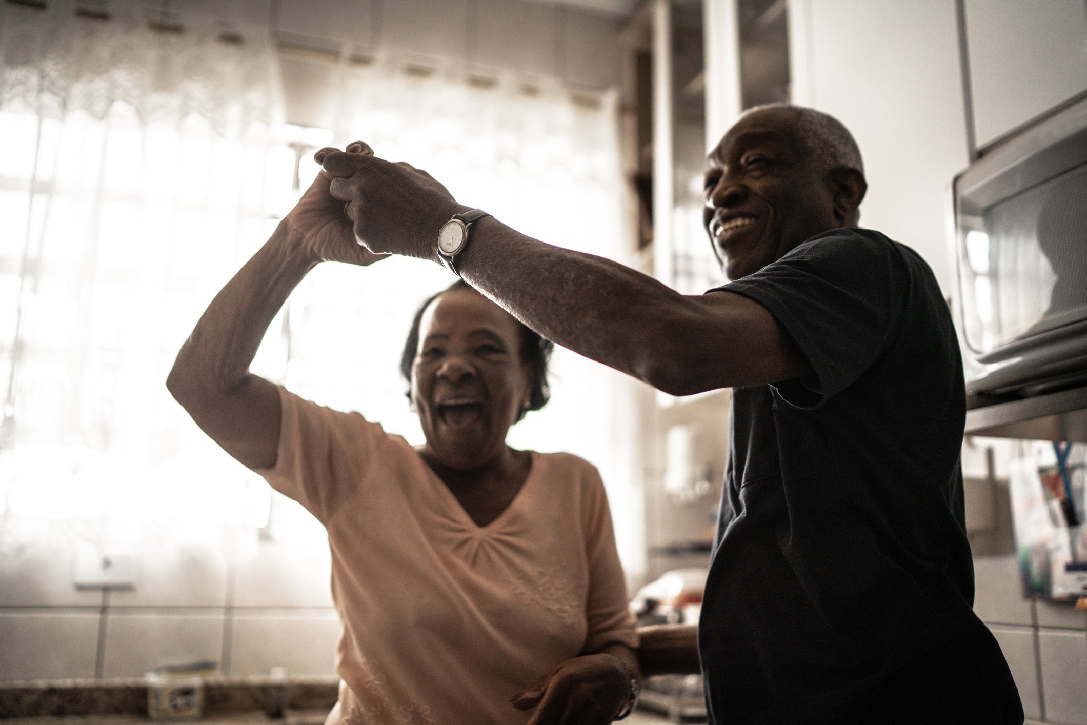 a senior couple dancing in their kitchen