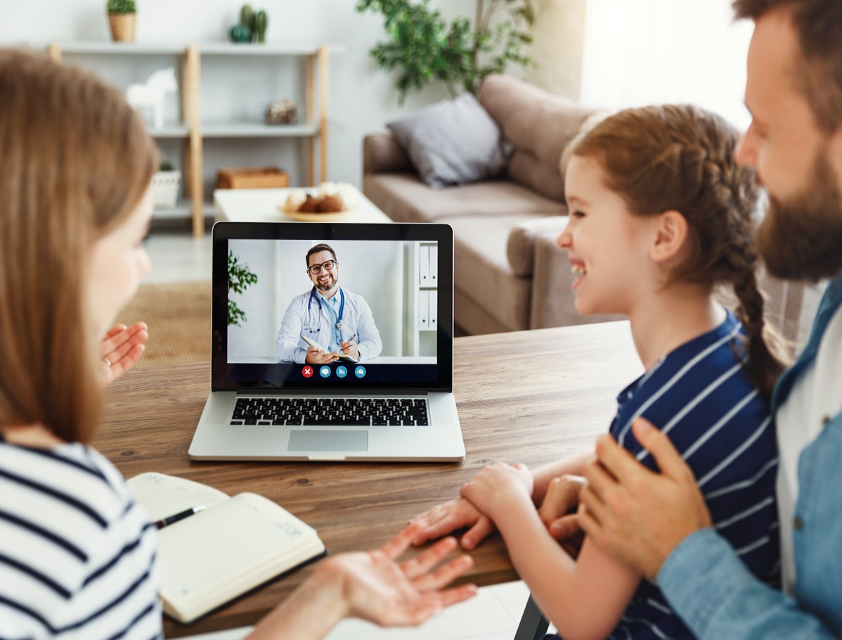 Familia frente a laptop en una teleconsulta con su médico