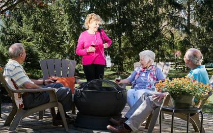 Woman with oxygen concentrator speaking with friends.