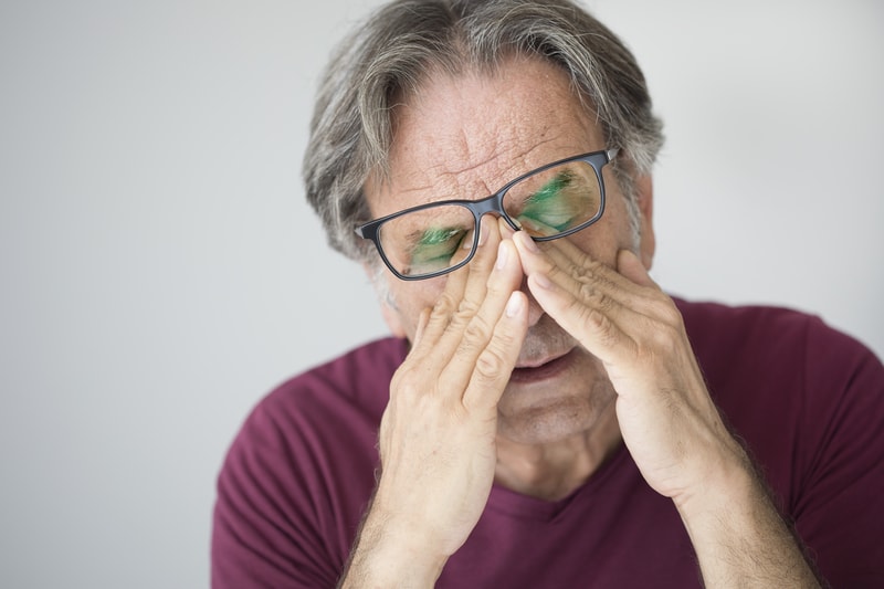 Man with his hands on his face.