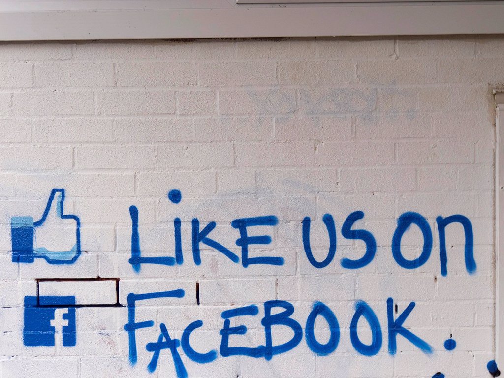 LIKE US ON FACEBOOK CALL TO ACTION PAINTED ON A BRICK WALL, UNITED KINGDOM