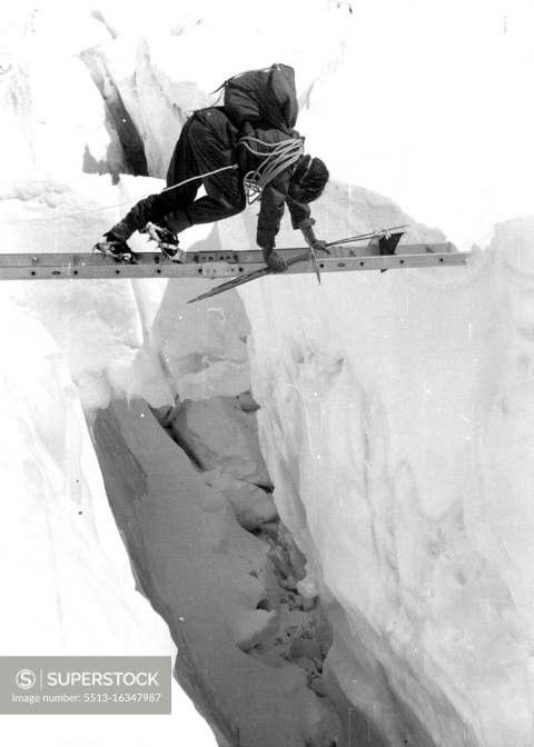 British Everest 1953 Expedition. A member crossing a crevasse with the aid of one of the special light ladders used by the Expedition.