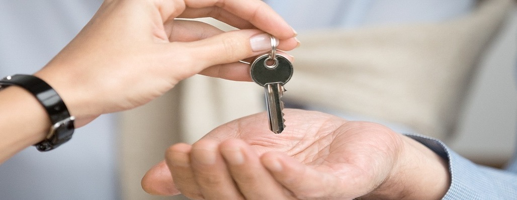 photo of someone giving someone else real estate keys