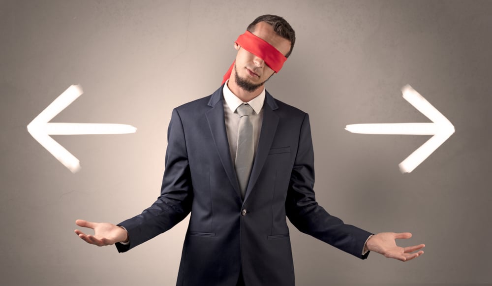 Covered eye businessman choosing between two directions