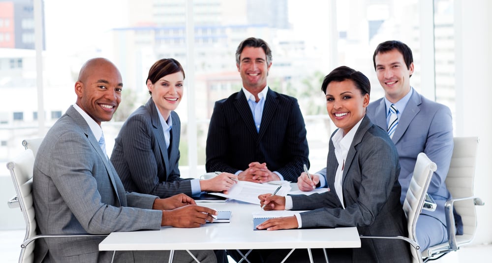 Business group showing ethnic diversity in a meeting smiling at the camera
