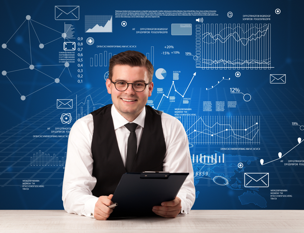 Young handsome businessman sitting at a desk with blue charts and data behind him