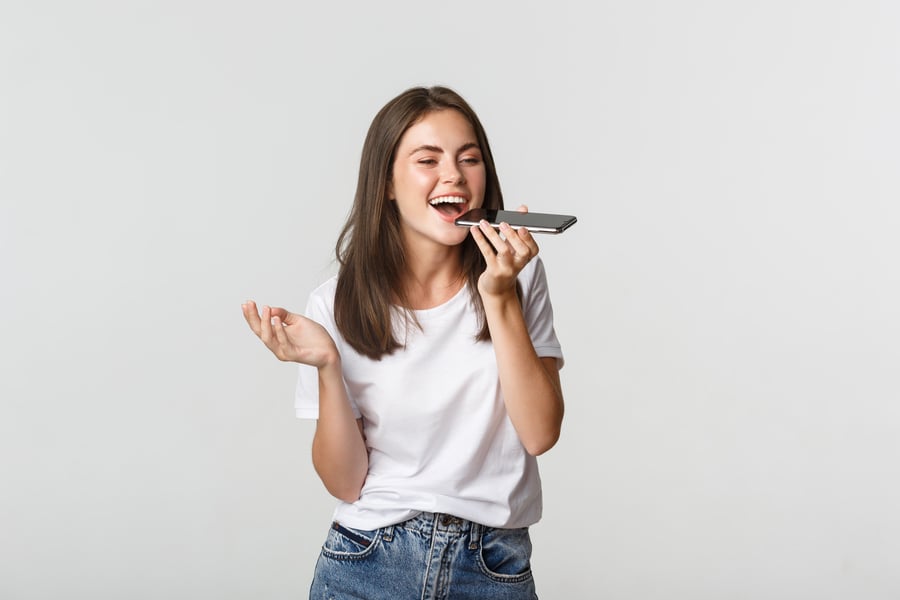 friendly-attractive-brunette-girl-talking-speaker-record-voice-message-smartphone-white