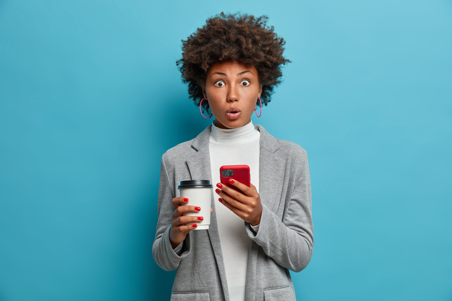 image-impressed-african-american-business-lady-holds-paper-cup-smartphone