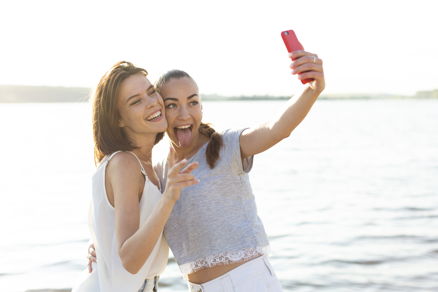 medium-shot-beautiful-friends-taking-selfie-lake
