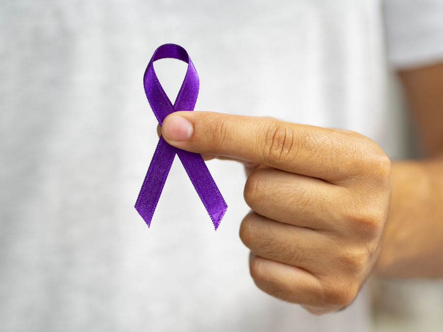 close-up-person-holding-up-purple-ribbon