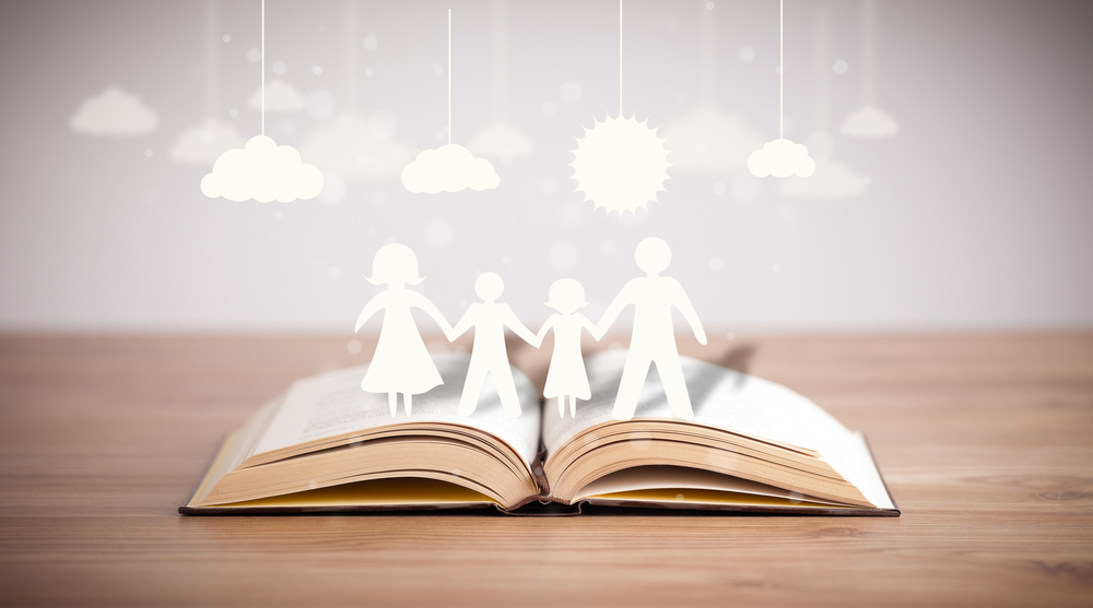 Cardboard figures of the family on opened book. The symbol of unity and happiness-1