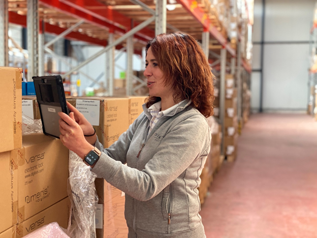 Lady on a tablet taking inventory in a wharehouse 