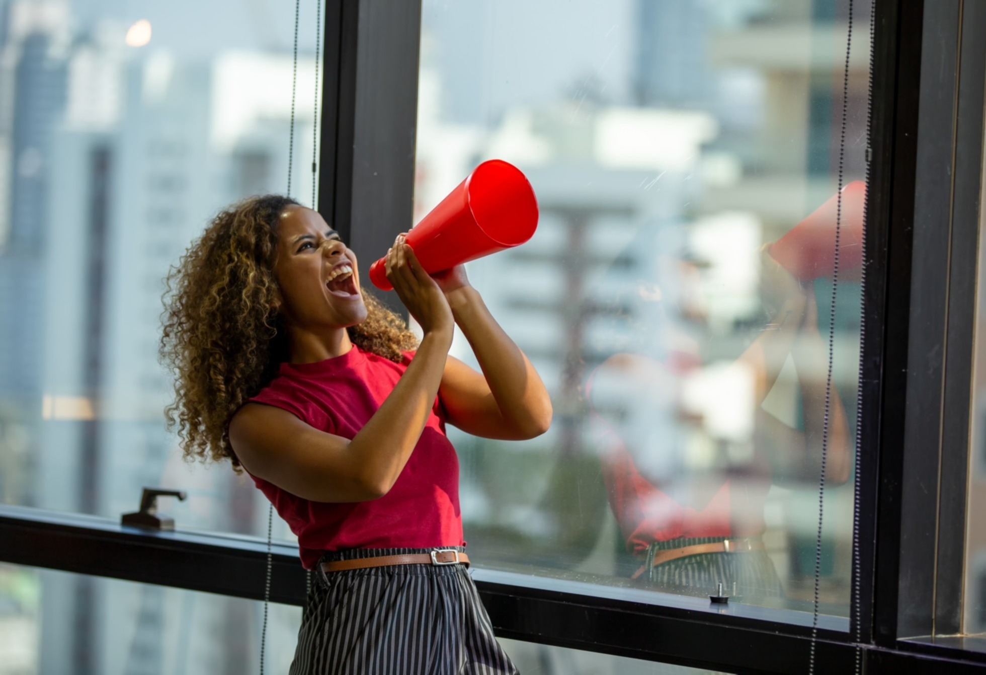 woman-shouting-on-megaphone-while-standing-against-wall_t20_mLJOrm-1-1