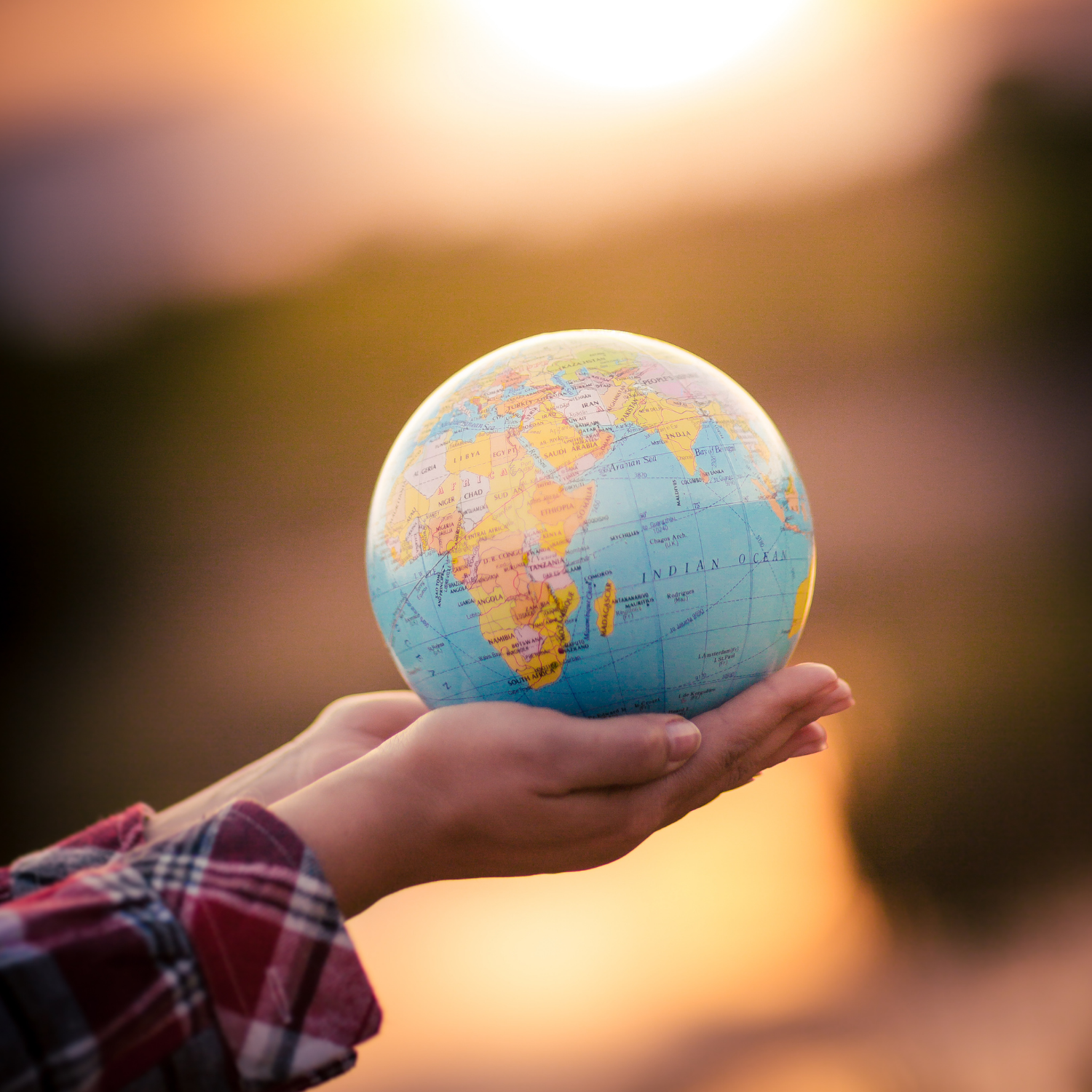 Two hands holding a large globe