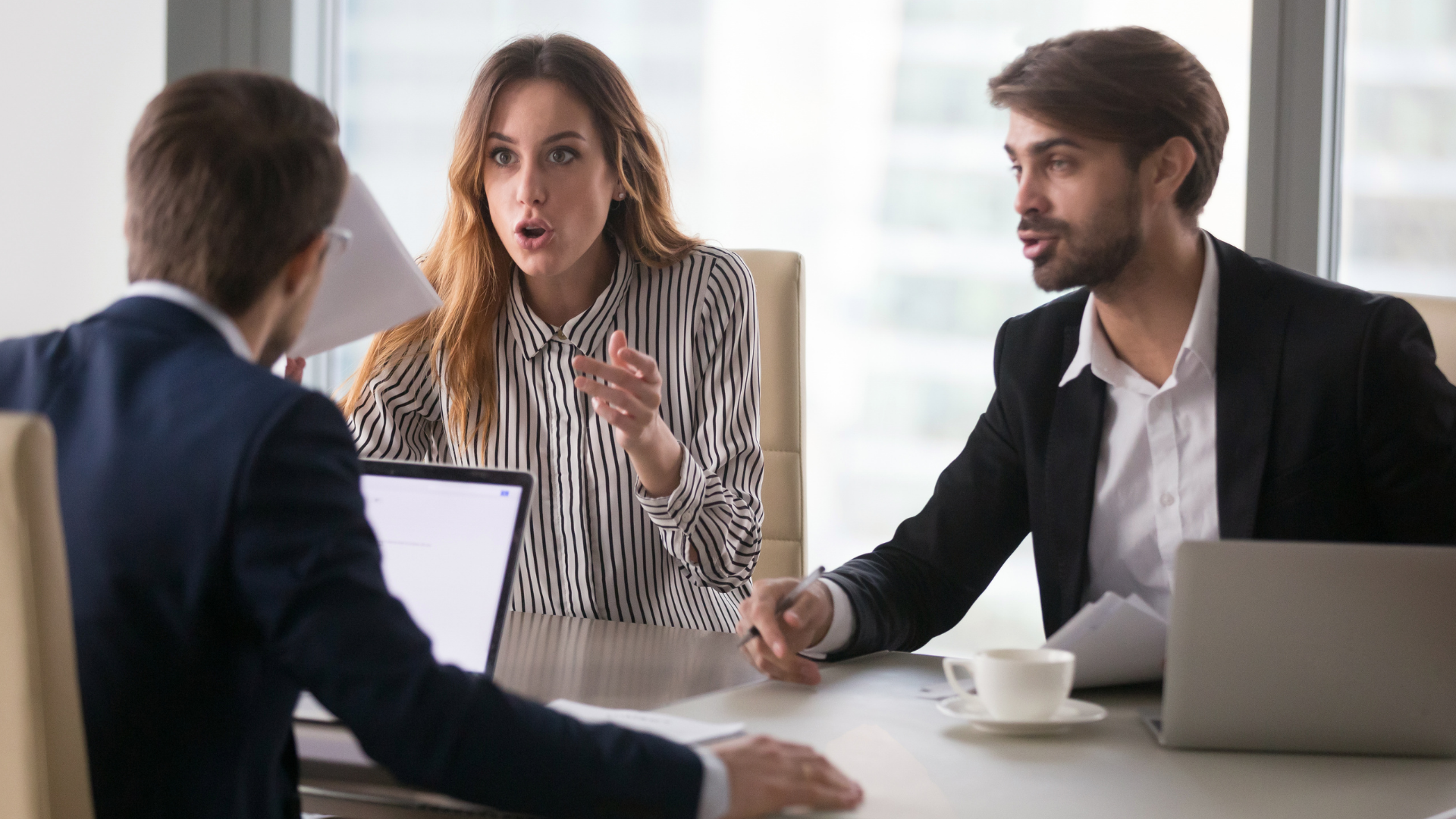 A group of people in business clothes that are arguing with one another