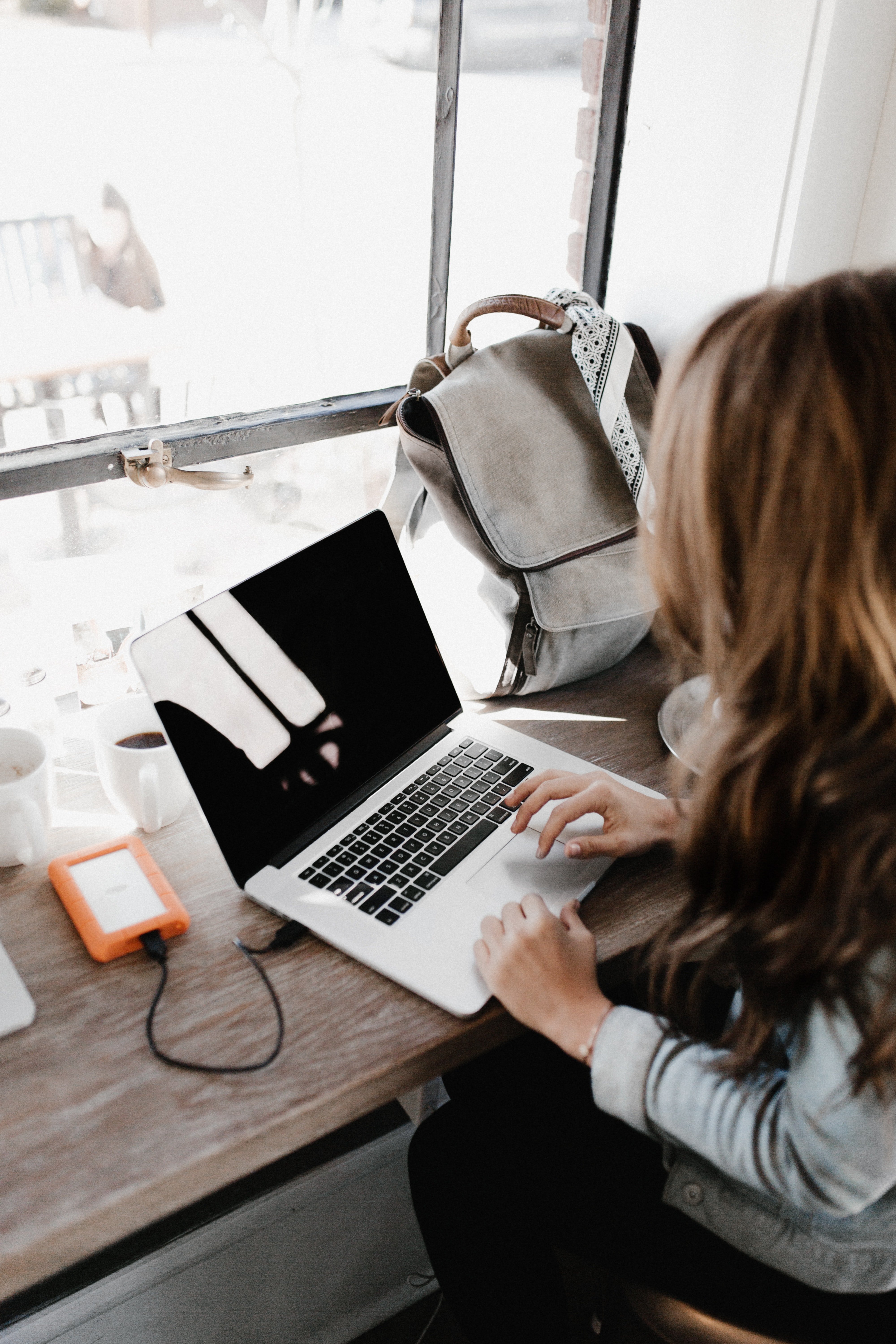 Image of a woman sitting and browsing something on her laptop.