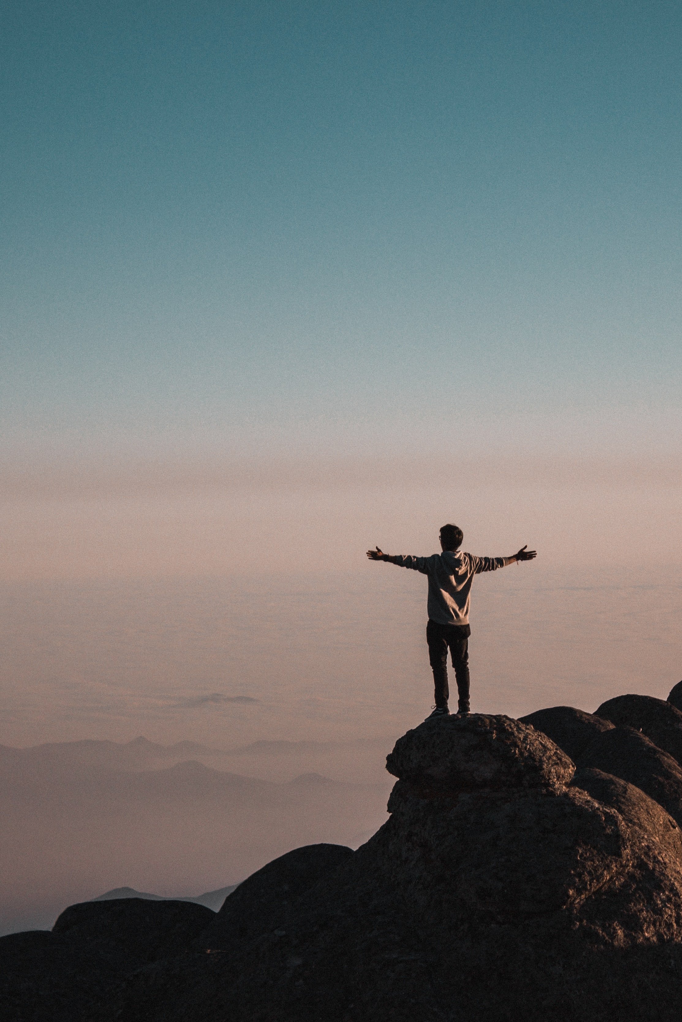 Decorative image for expansion showing a man conquering a mountain with his arms open