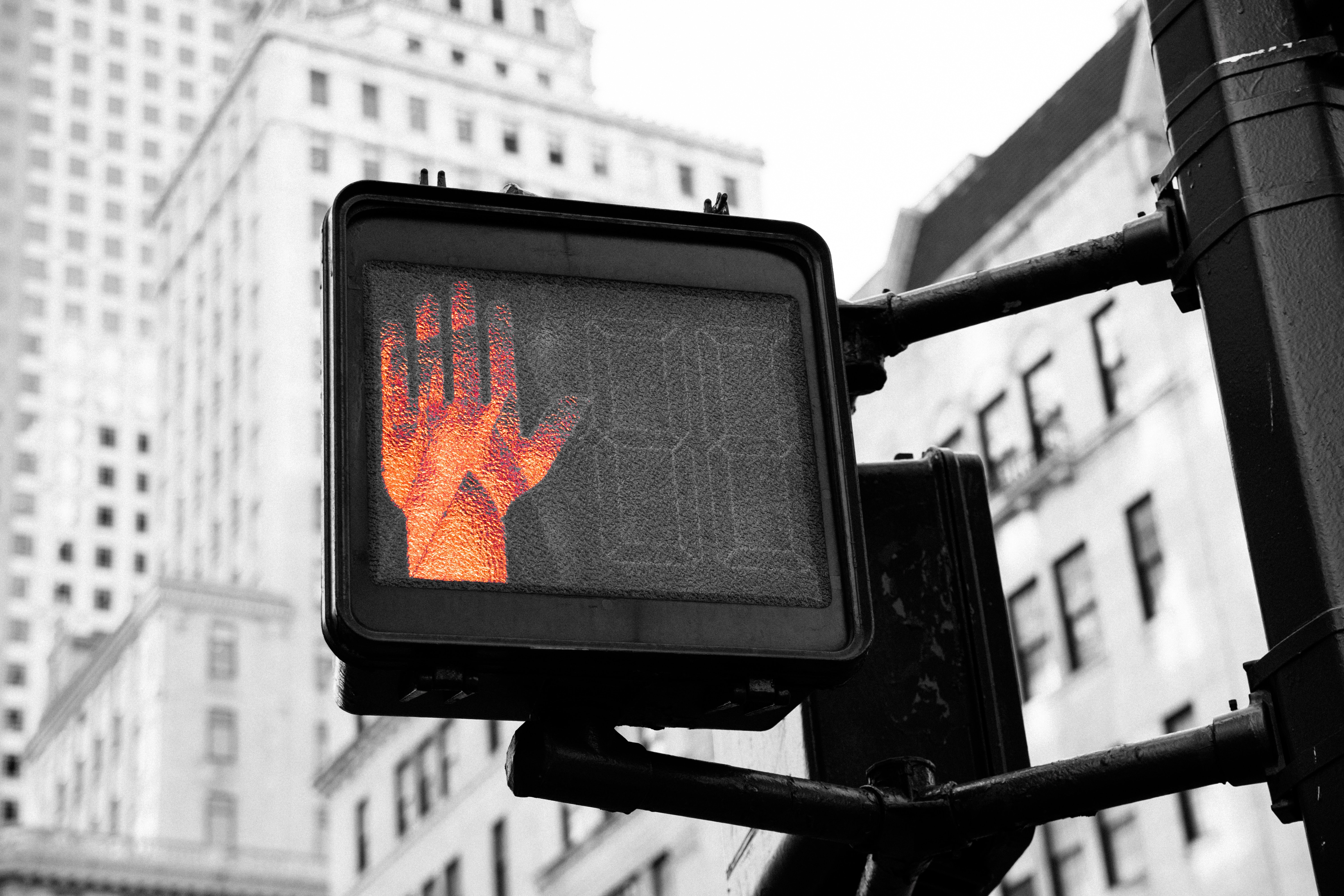 Photograph of a walk signal with the stop hand illuminated