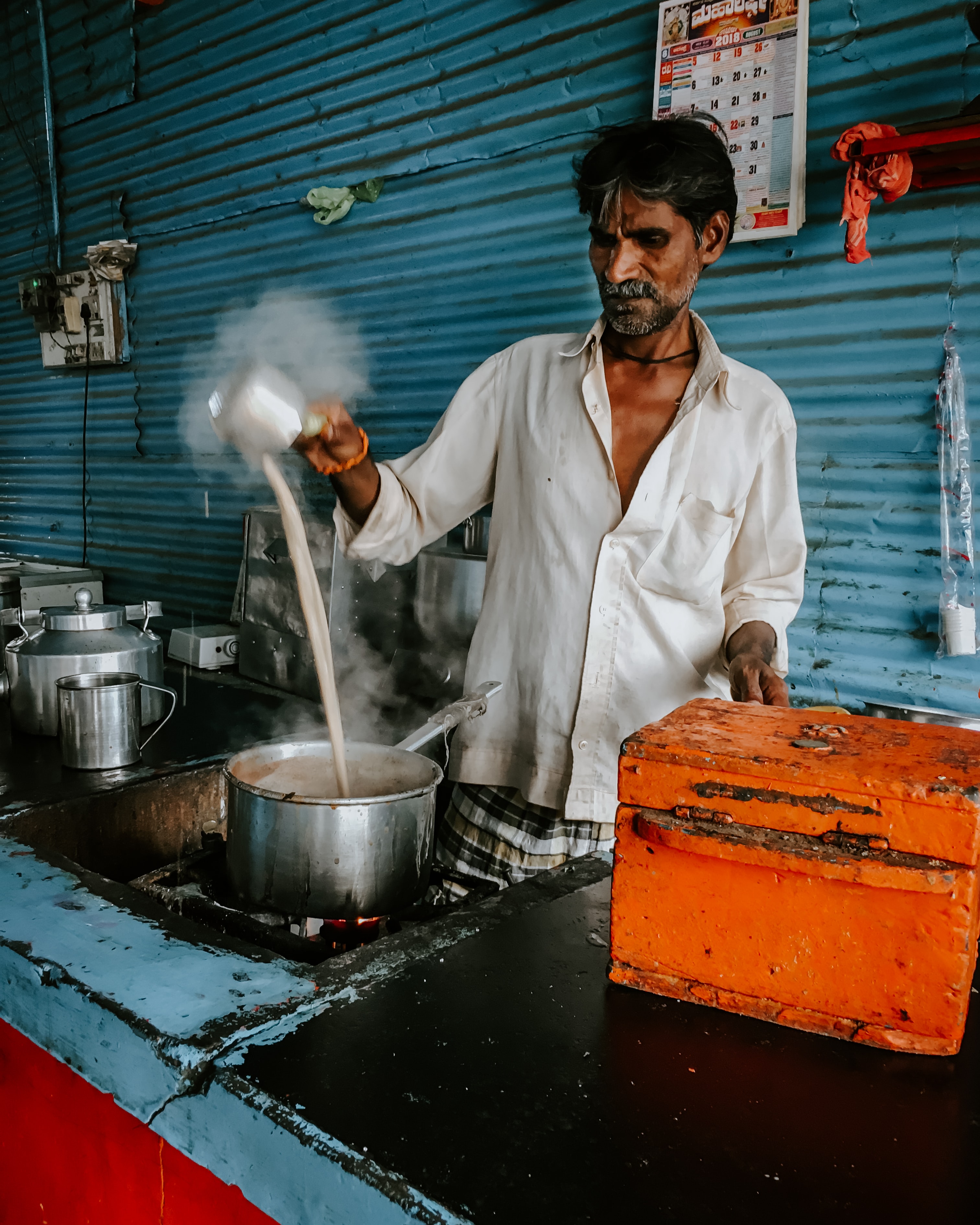 A man prepares chai tea in India.