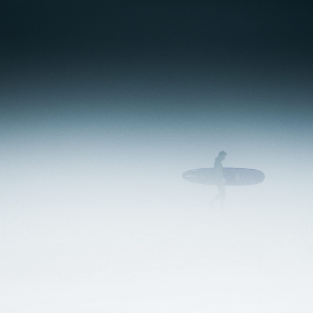 A surfer in Tofino on a foggy day, a surfer's paradise on Vancouver Island 