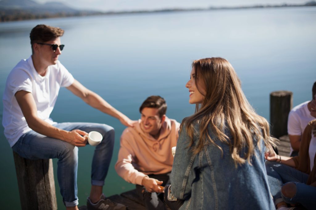 a group of friends laughing and smiling at a port near the sea making them the perfect TripMate