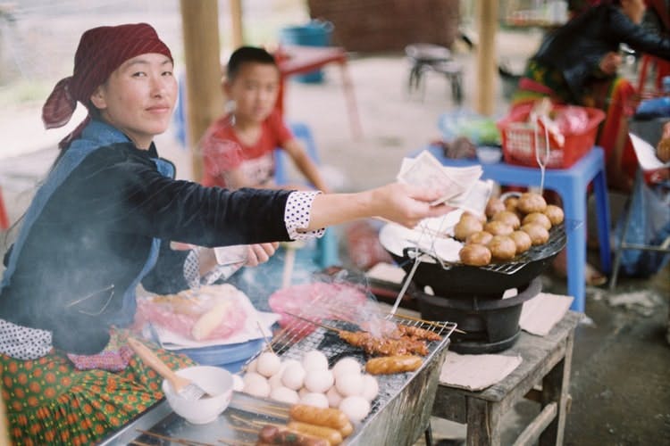 woman offering food at a Vietnamese market