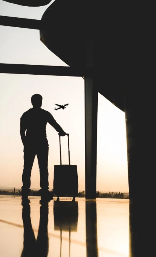 Mann mit Koffer am Flughafen