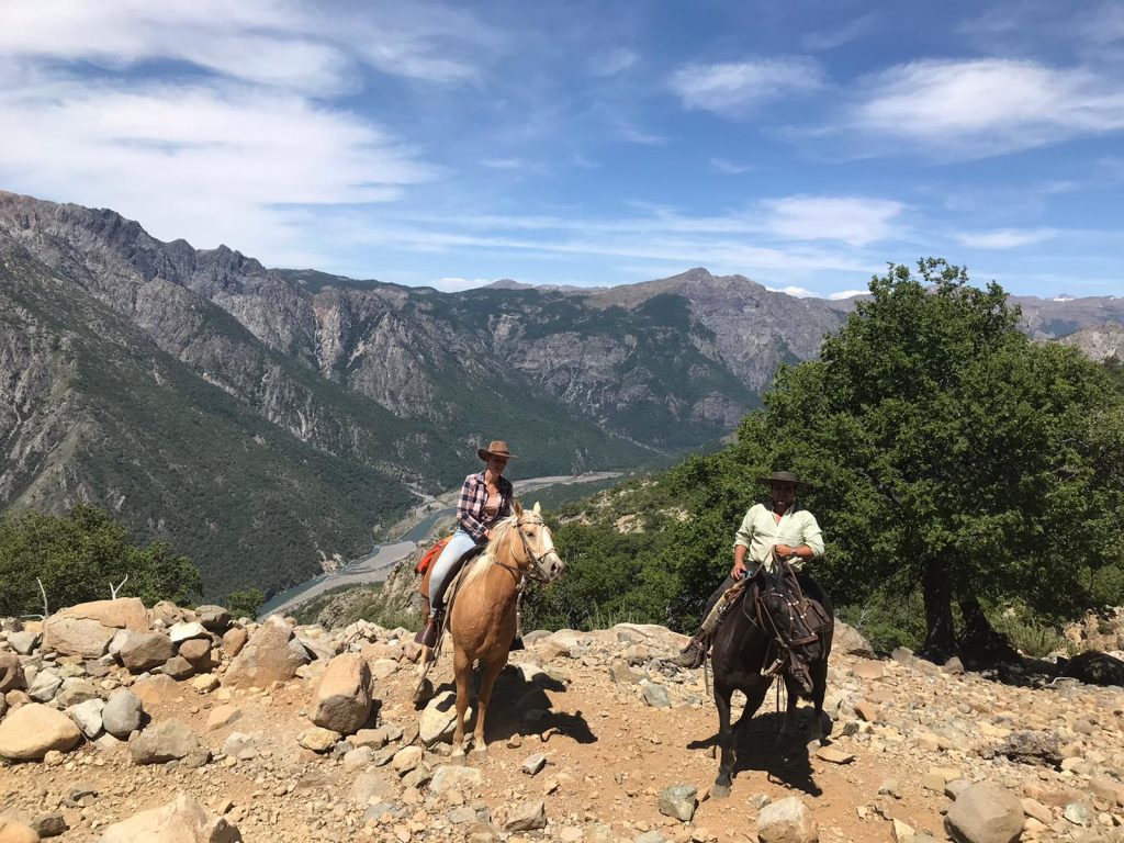 Two people on horseback in the mountains on a clear day