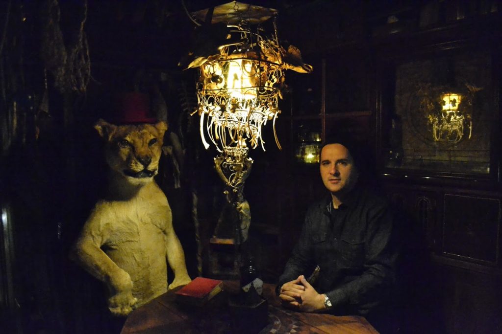 traveling with professional tour guides man sat in a dark room with a stuffed tiger next to him