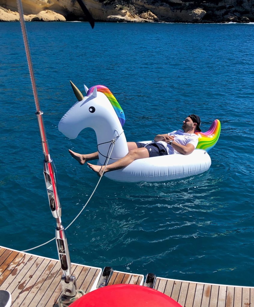 Crewmitglied entspannt auf schwimmendem Einhorn im Wasser