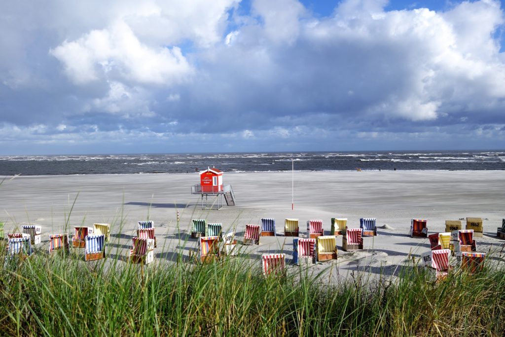 a beach on the Frisian Islands with little colourful chairs located in one of the largest federal states in Germany