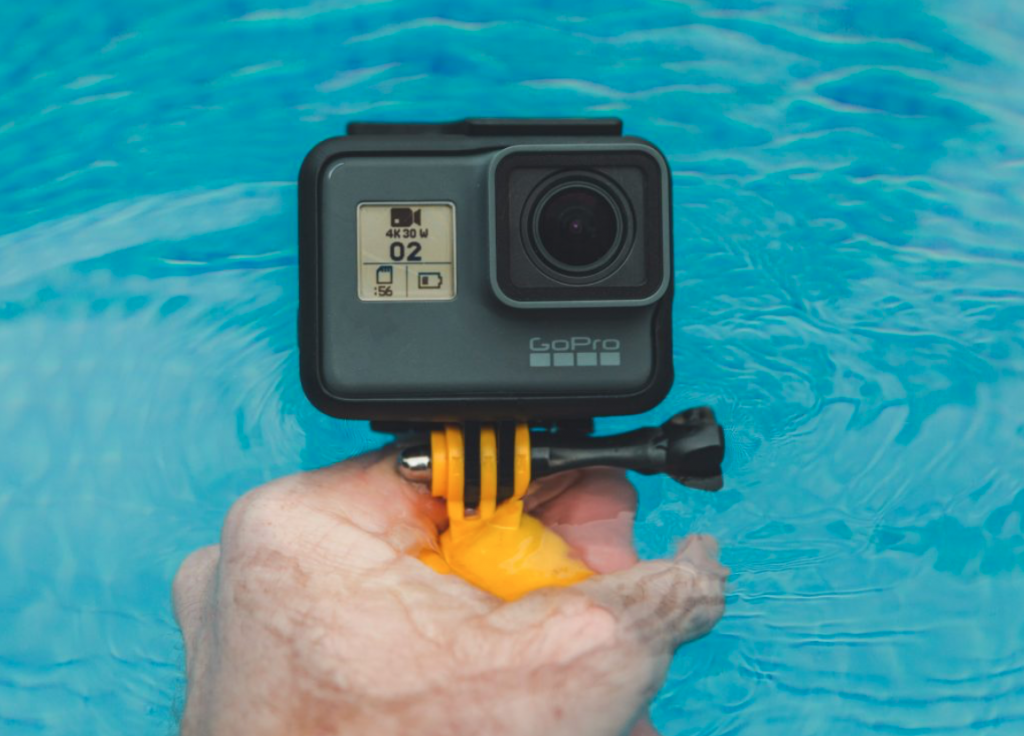 An underwater camera that captures someone, which is the perfect travel essential for a vacation by the sea.