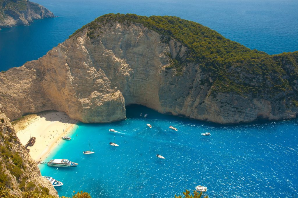 a bay on the beautiful island Zakynthos in Greece with little boats and lush blue water