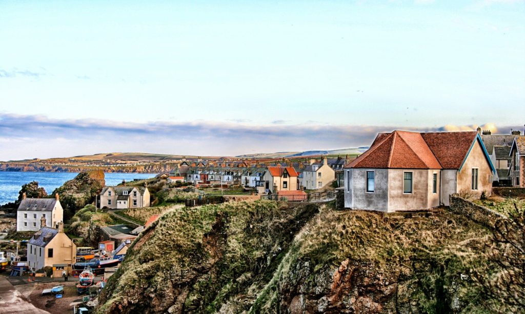 Aussicht auf St Abbs in Schottland mit Häusern, Klippen und dem Meer 