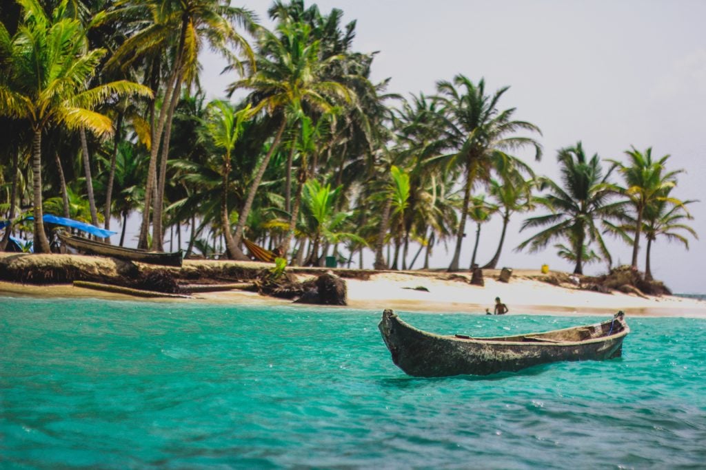 Ein Bild von Panama, das blaue Meer mit einem Boot und Palmen im Hintergrund