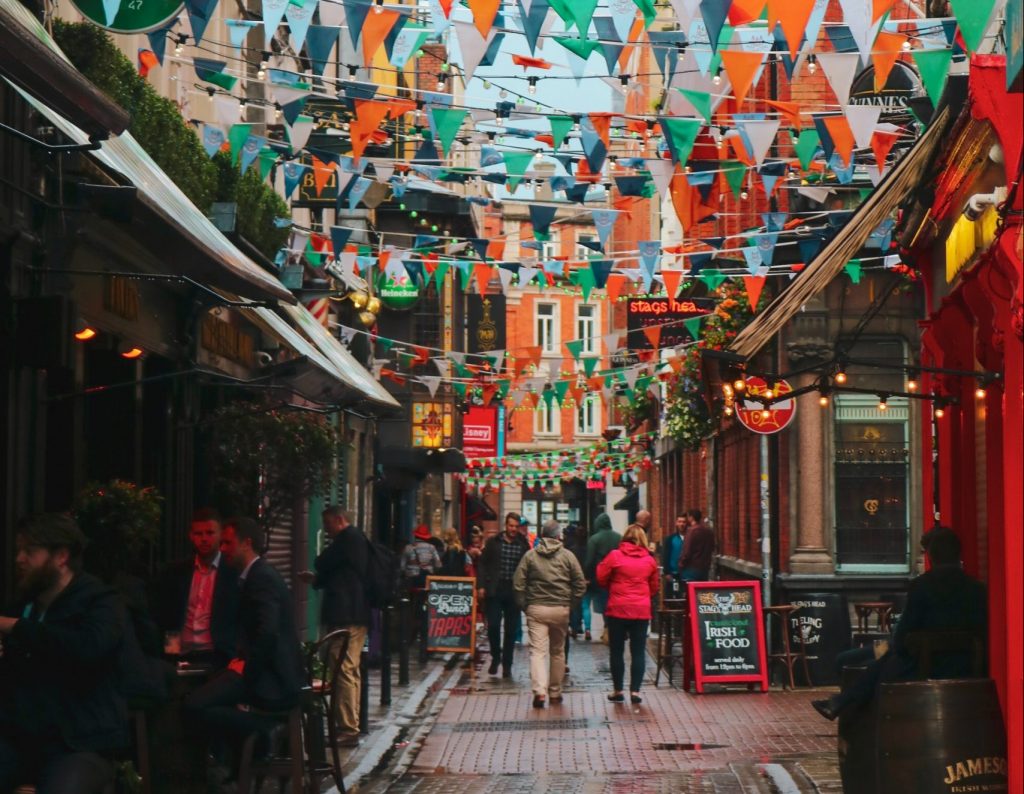 Temple bar in Ireland with people walking down the streets.