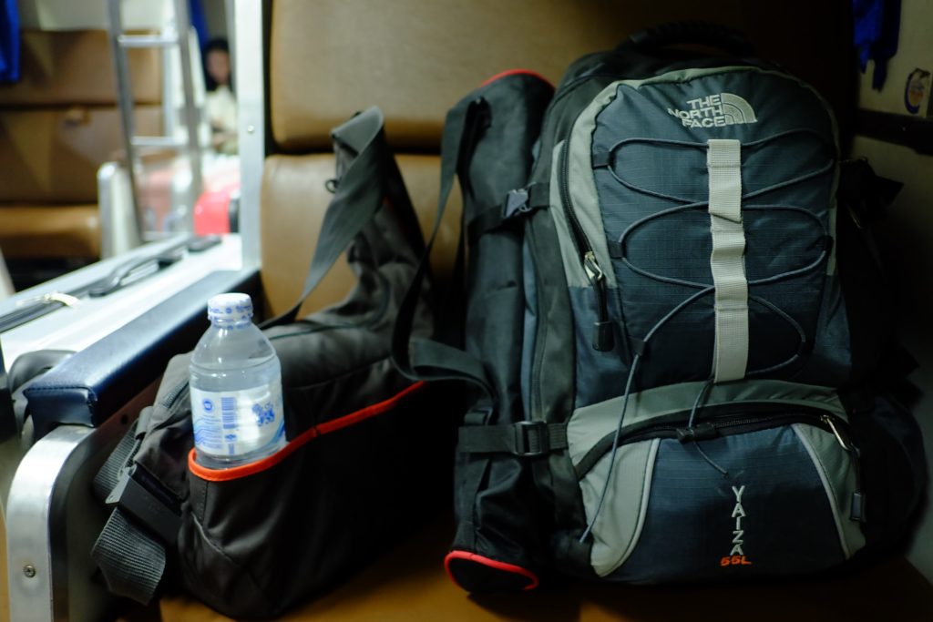 The north face backpack and water bottle on a seat 