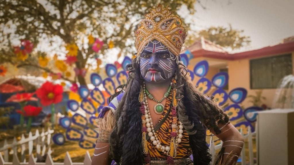 A man with colorful carnival costume somewhere in the world.