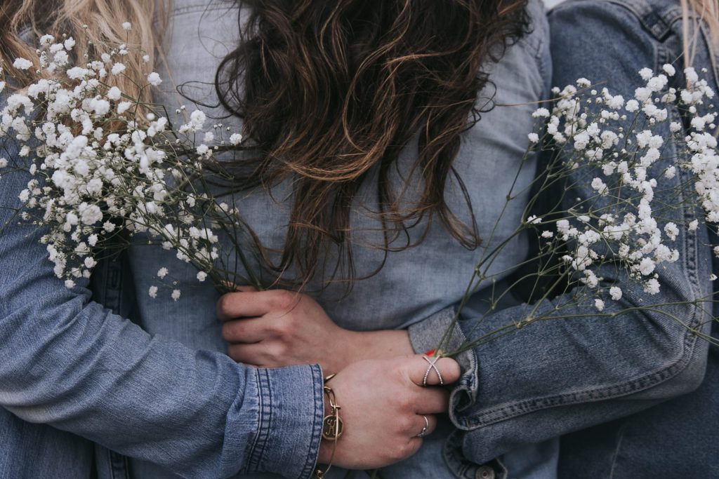 three women standing together and hugging each other 