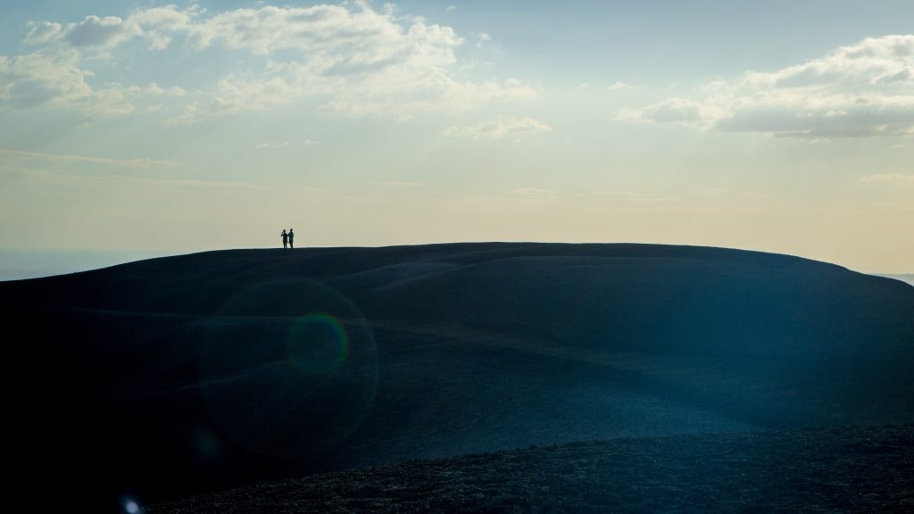 2 people standing on top of a volcano in Leon, Nicaragua.