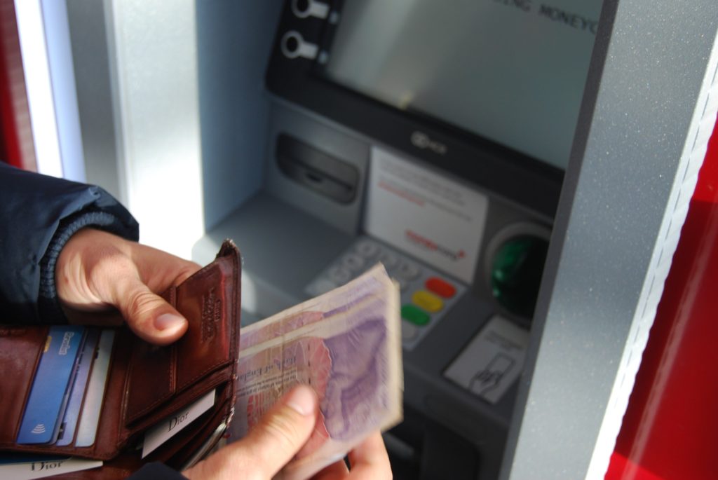 Somebody Taking Out Money At a Cash Point a travel tip in Vietnam