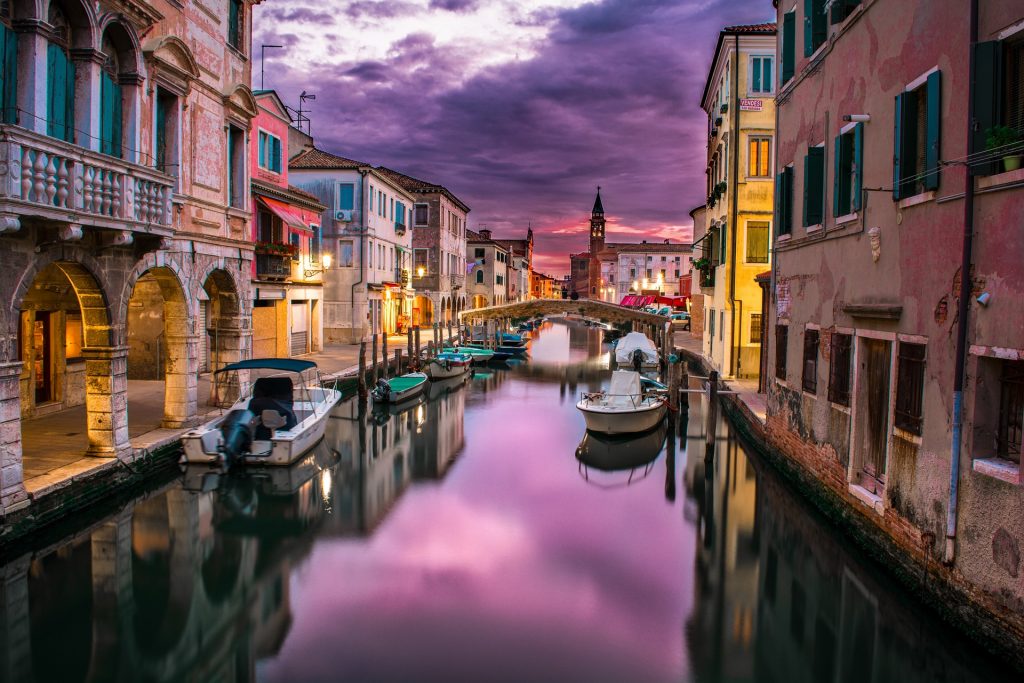 Promote a trip by using images from Pixabay like this one of the canals of Venice at sunset