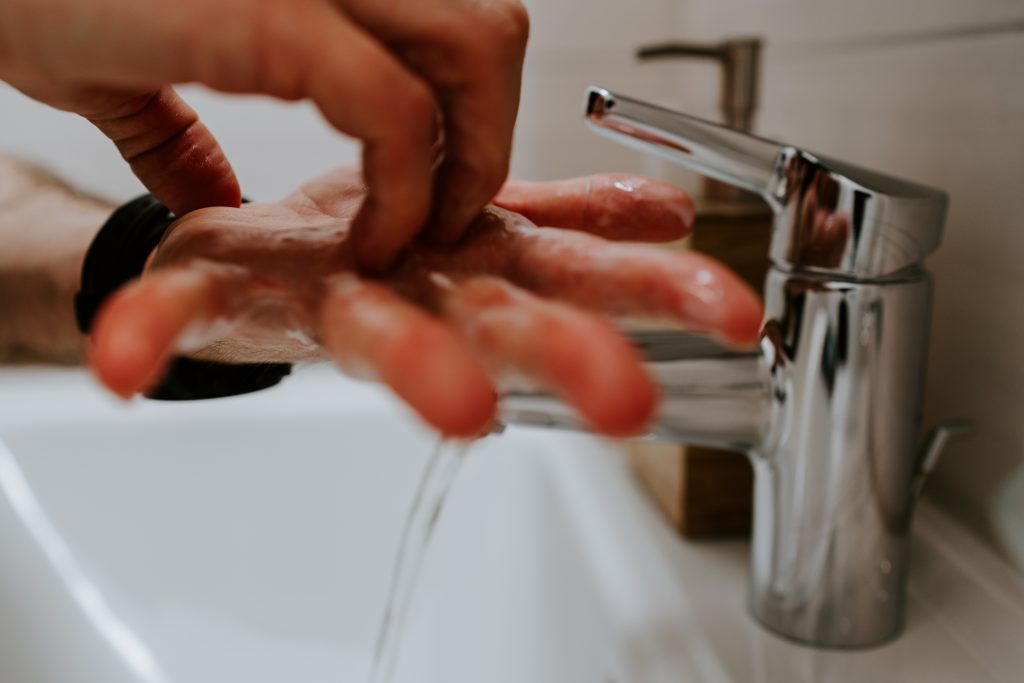 a man washing his hands in a sink.