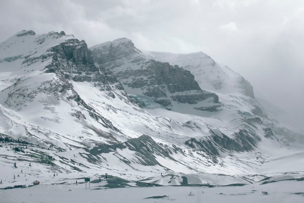 Schneebedeckte Berge in Kanada vor einem gefrorenen See.