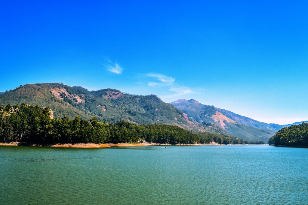 The blue sea in front of beautiful mountains and green trees to experience Kerala