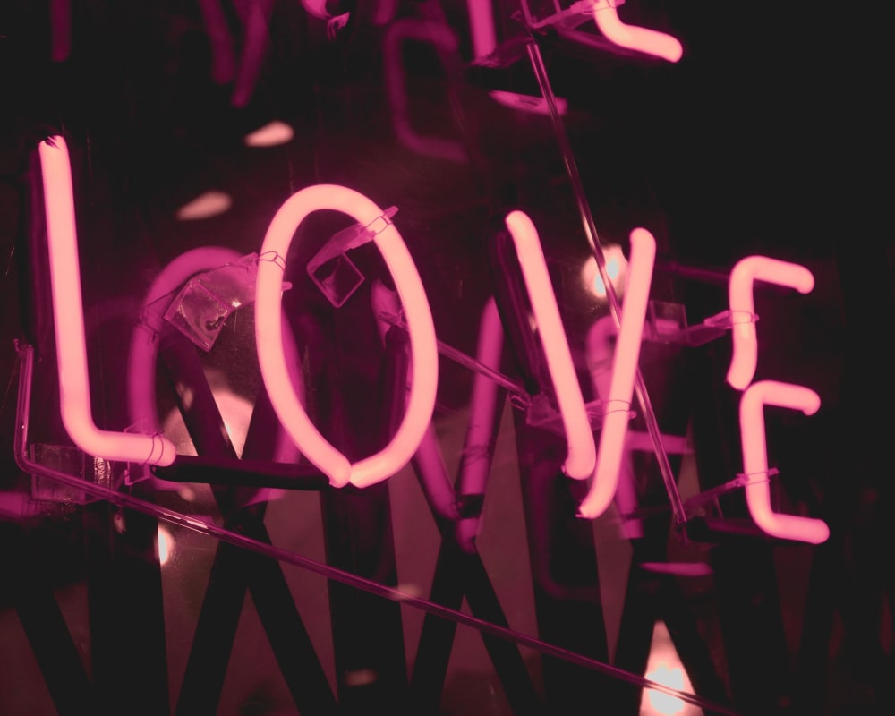 Bücher und Filme zum Thema Reisen: Rosa Neonschild mit dem Wort Love 