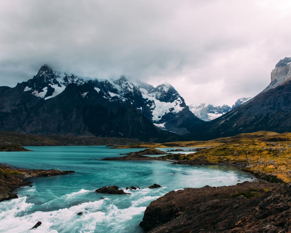 eisblauer Fluss und schwarze Berge mit Schnee in Patagonia 